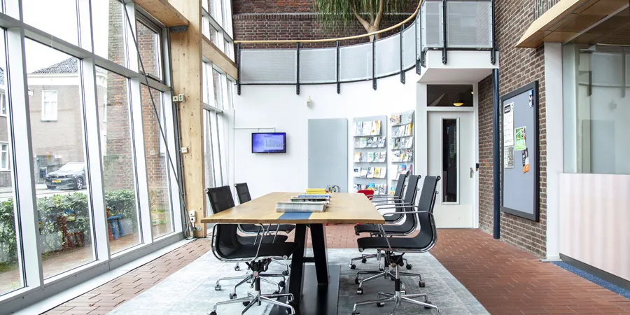 Een lege vergaderruimte met stoelen en een vergadertafel